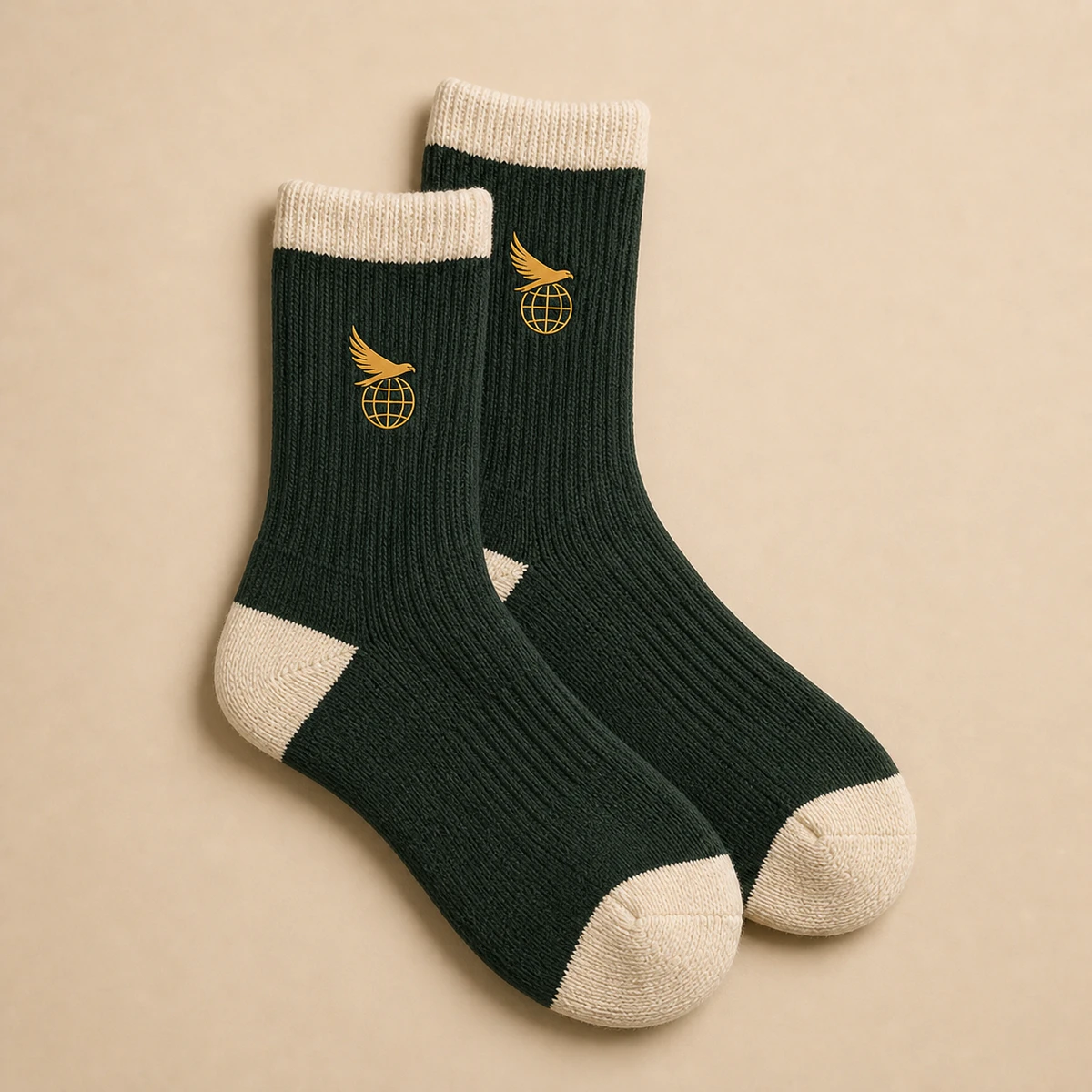 Cream and forest-green cushioned crew socks with a small Hawk Nest globe mark